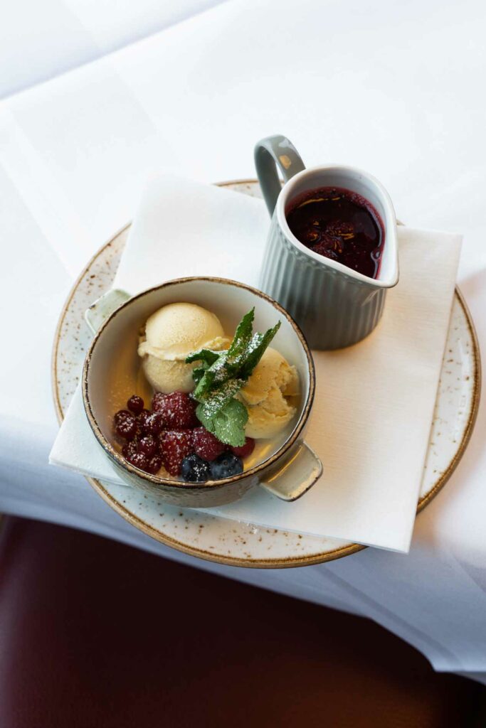 Kleines angerichtetes Gericht mit Sauce, Gemüse und separatem Saucenkännchen.