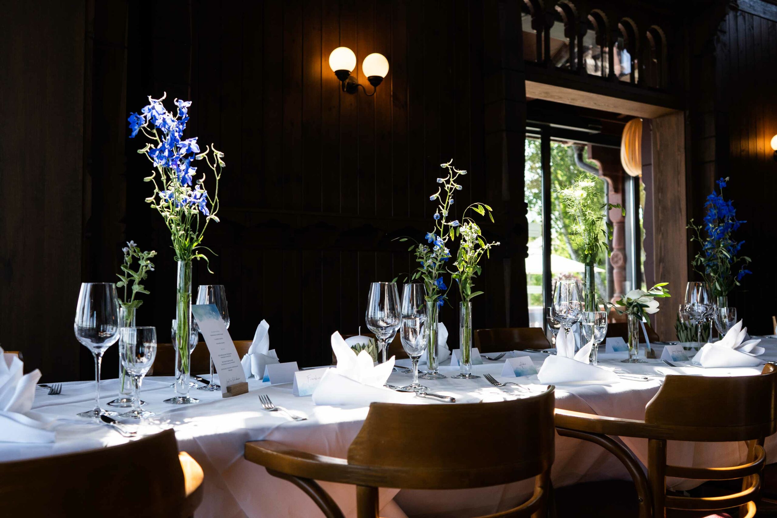 Festlich gedeckter Tisch mit blauen Blumen.