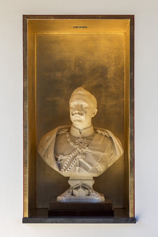 Historische kaiserliche Büste vor beleuchteten Hintergrund.