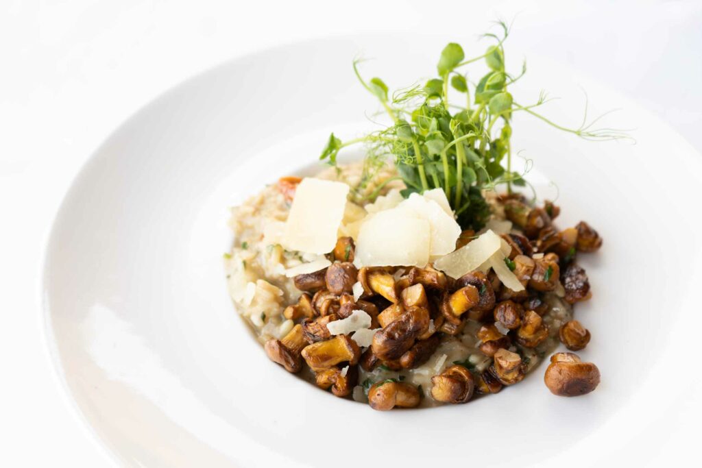 Angerichtete Bowl mit Hülsenfrüchten, Kräutern und cremiger Garnitur.