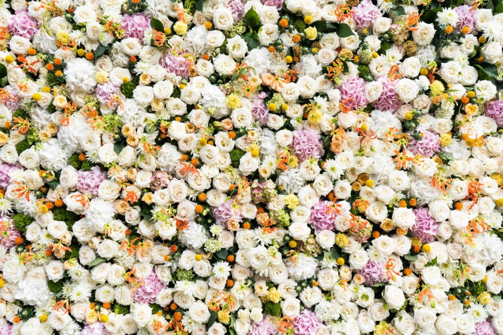 Bunte Blumenwand mit vielen hellen und rosafarbenen Blüten.