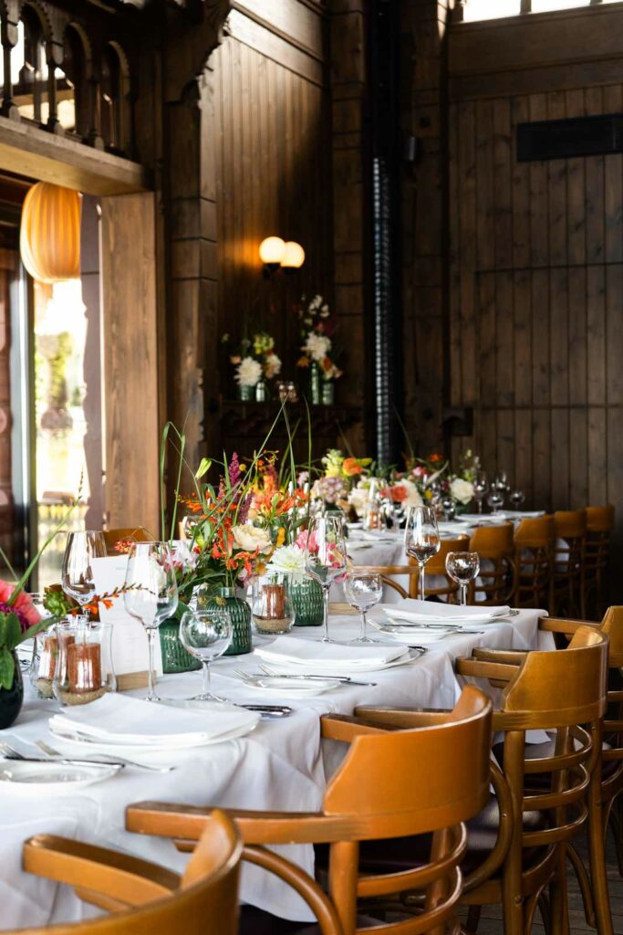Festlich gedeckte Tische mit Blumen und Gläsern im historischen Restaurantambiente.